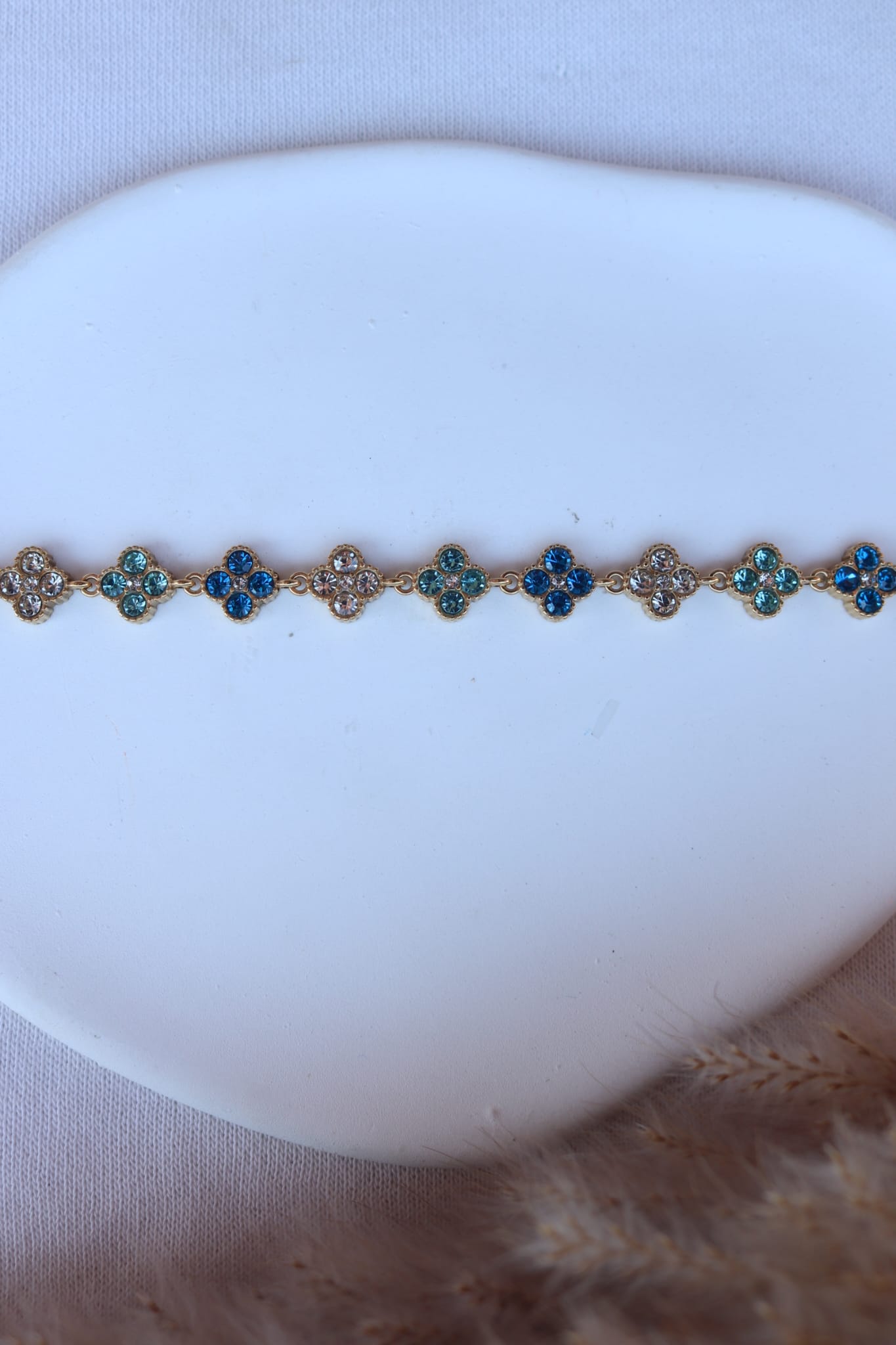 Pulseira de Aço Dourado Inspiração Swarovski de Trevo com Brilhantes Azuis Claro
