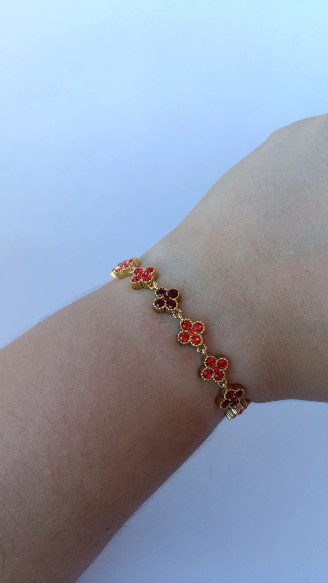 Pulseira de Aço Dourado Inspiração Swarovski de Trevo com Brilhantes Vermelhos e Laranja