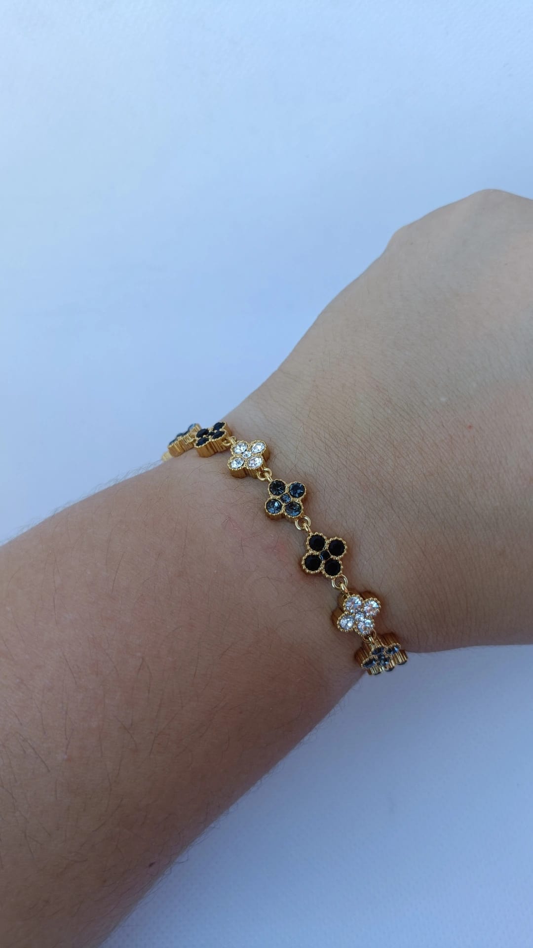 Pulseira de Aço Dourado Inspiração Swarovski de Trevo com Brilhantes Pretos e Cinzentos