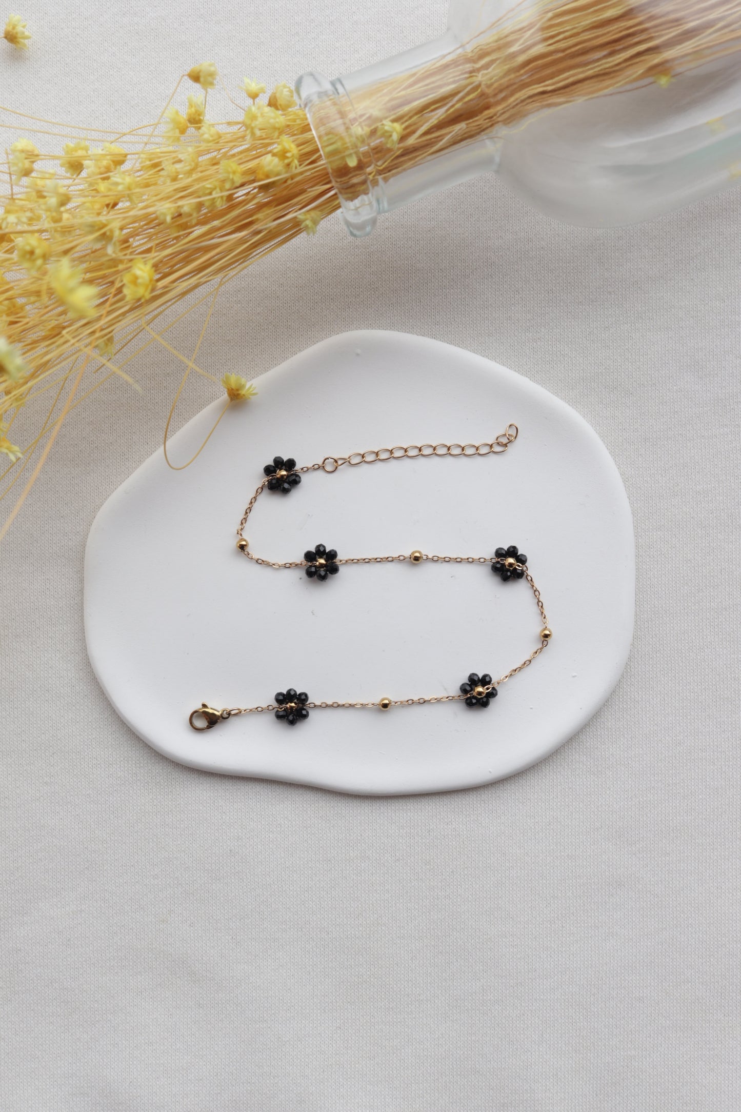 Pulseira de Aço Dourado de Pé com Flor Preta de Missangas