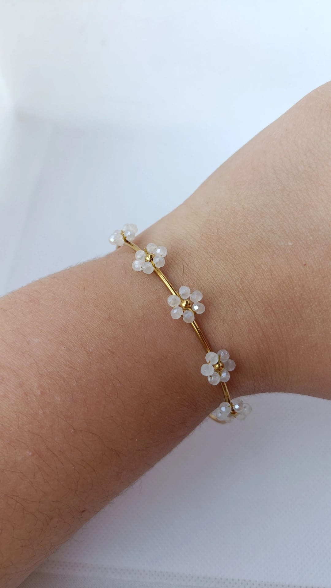 Pulseira de Aço Dourado Rígida com 5 Flores Brancas