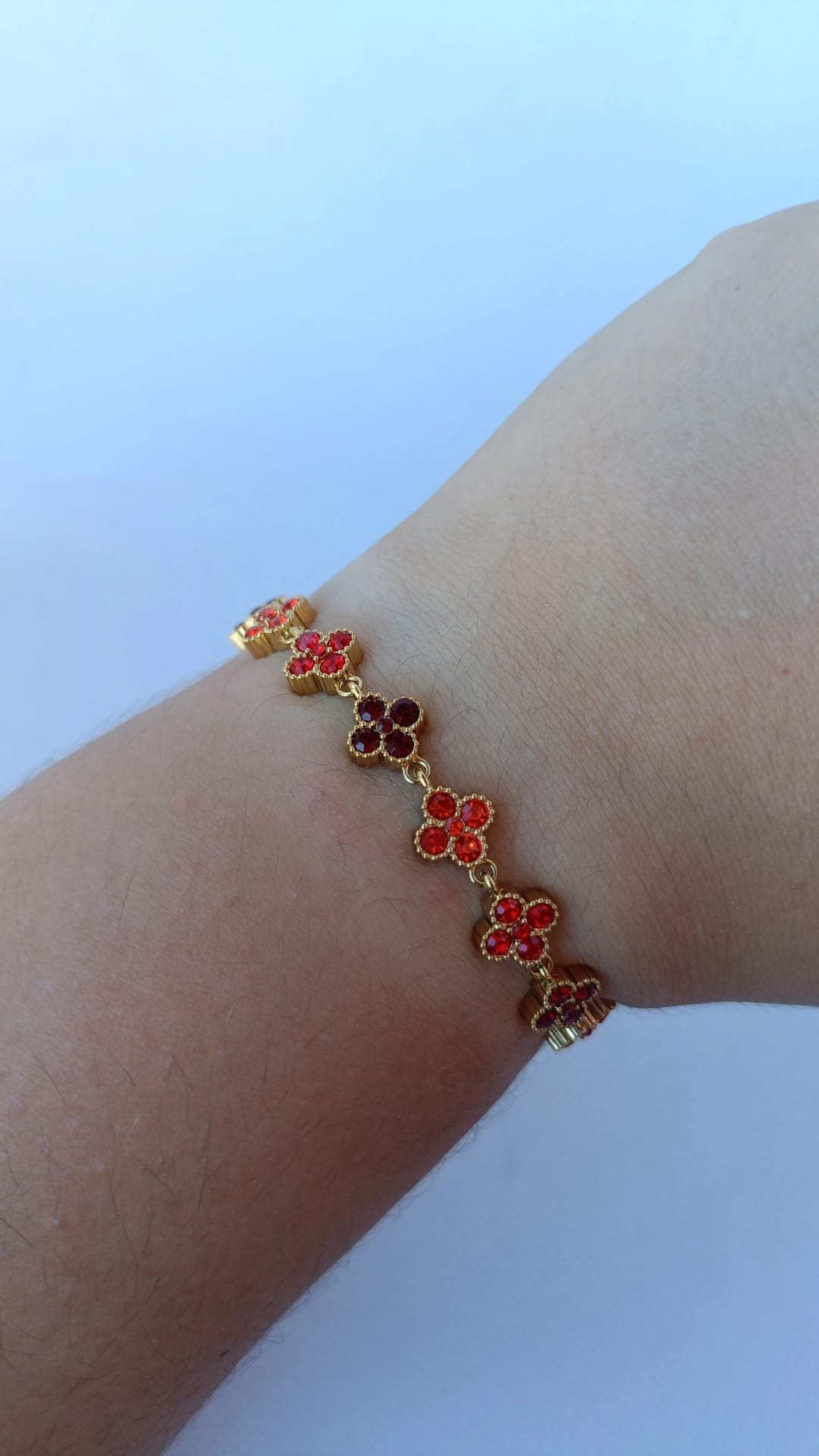 Pulseira de Aço Dourado Inspiração Swarovski de Trevo com Brilhantes Vermelhos e Laranja