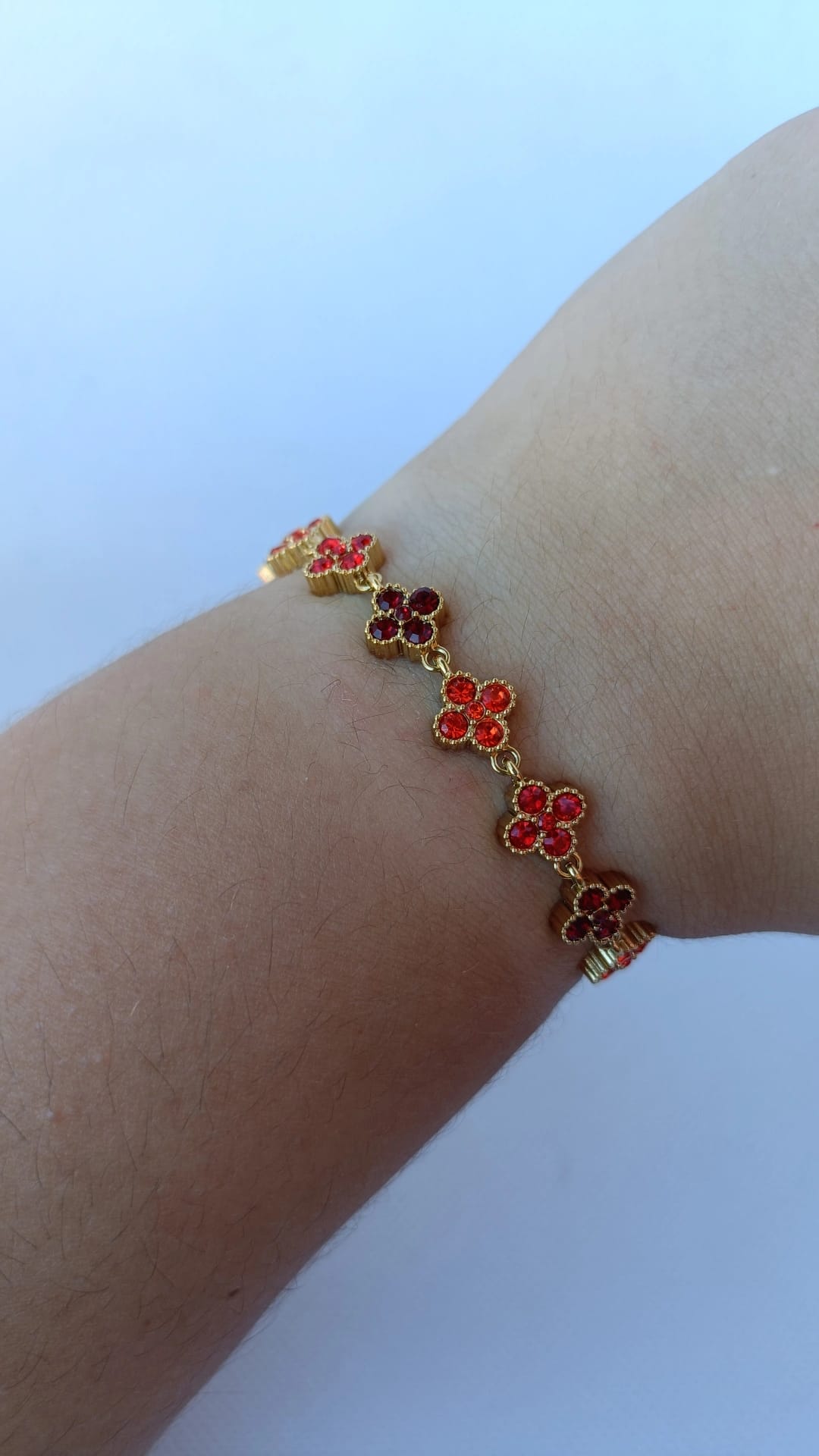 Pulseira de Aço Dourado Inspiração Swarovski de Trevo com Brilhantes Vermelhos e Laranja