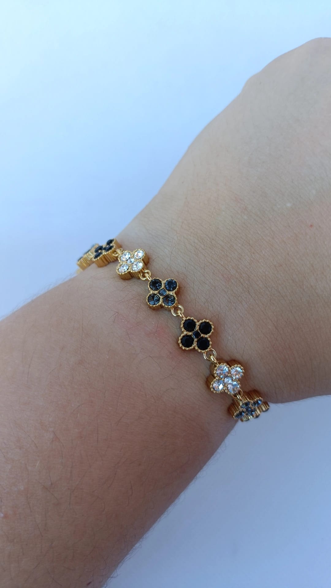 Pulseira de Aço Dourado Inspiração Swarovski de Trevo com Brilhantes Pretos e Cinzentos