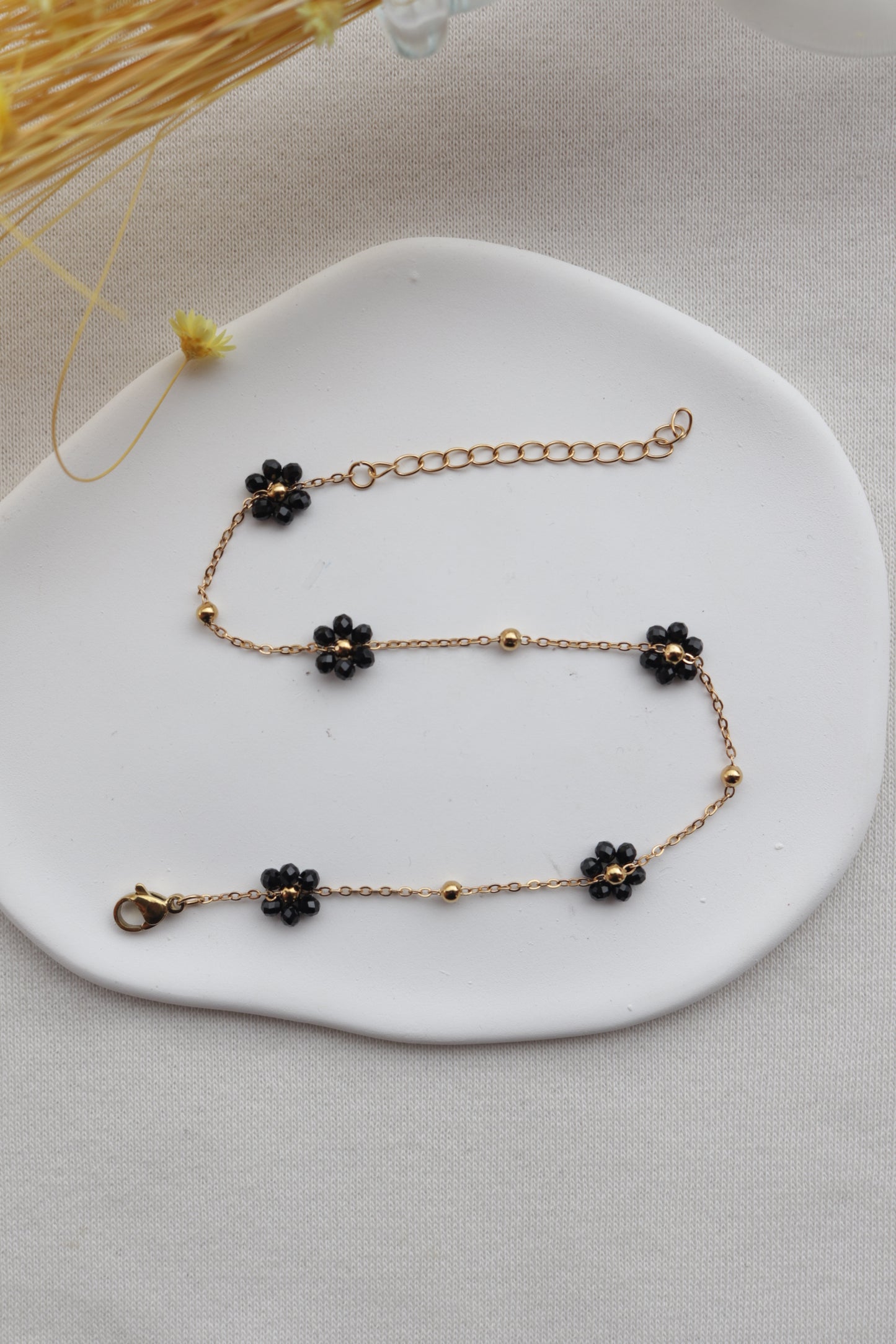 Pulseira de Aço Dourado de Pé com Flor Preta de Missangas