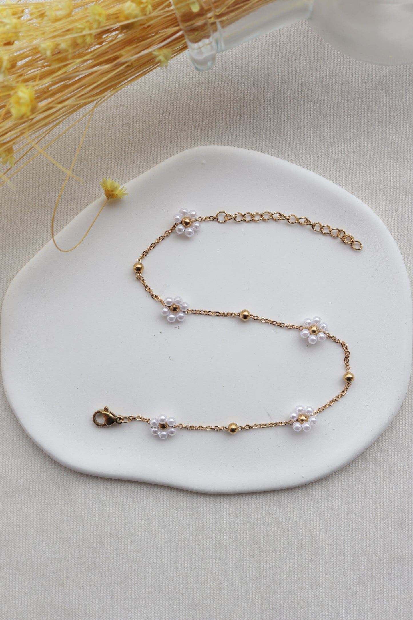 Pulseira de Aço Dourado de Pé com Flor Branca de Missangas