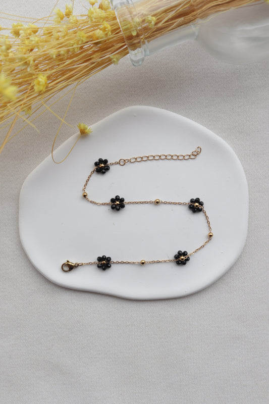 Pulseira de Aço Dourado de Pé com Flor Preta de Missangas