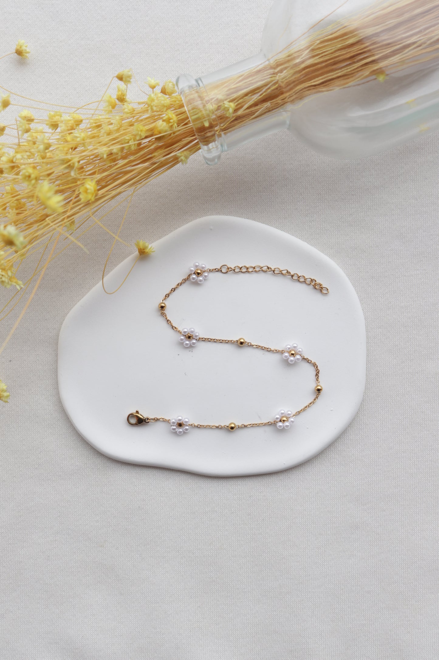 Pulseira de Aço Dourado de Pé com Flor Branca de Missangas