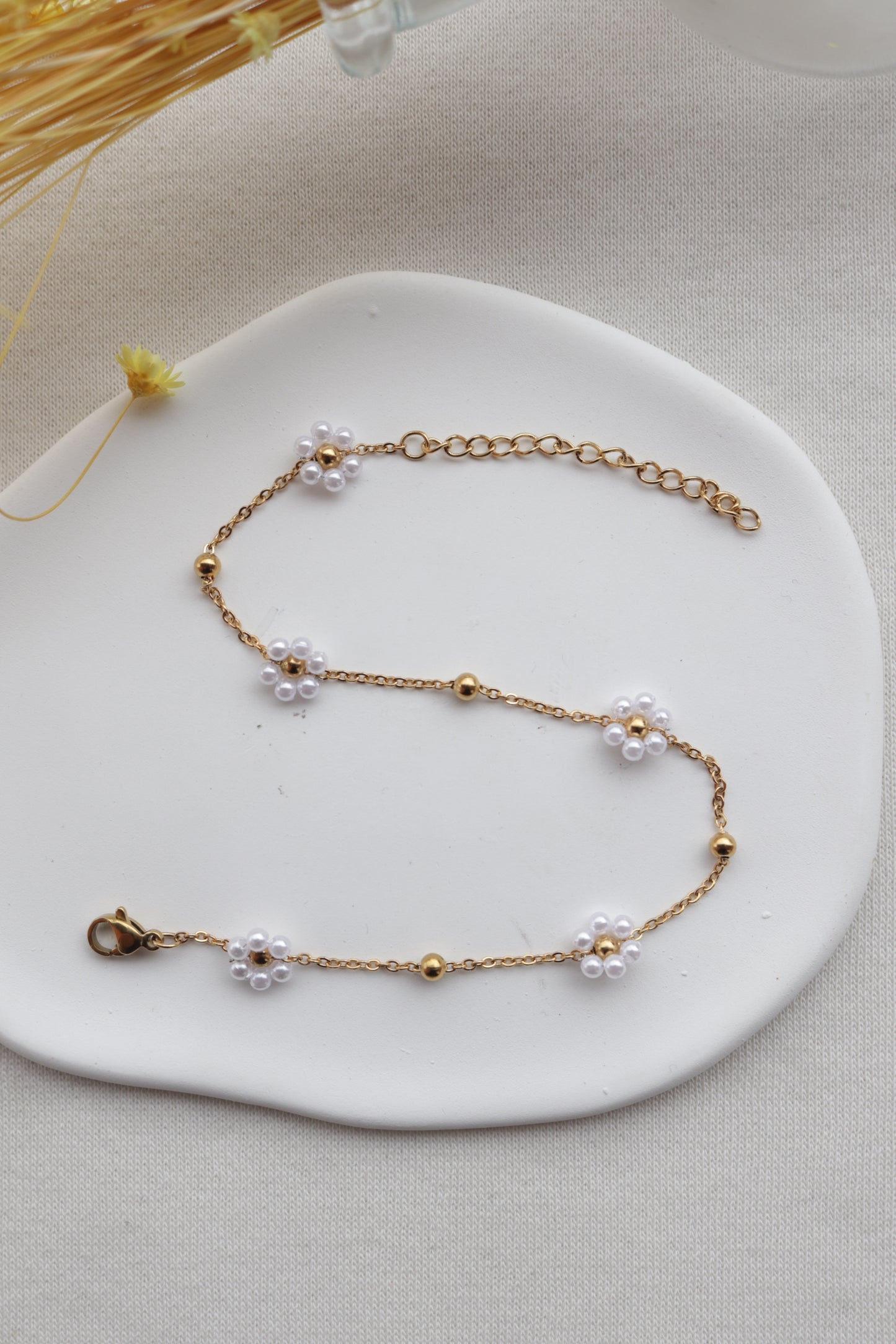 Pulseira de Aço Dourado de Pé com Flor Branca de Missangas